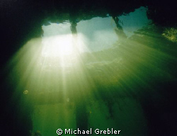 Looking up at the light beams coming through the fisherme... by Michael Grebler 